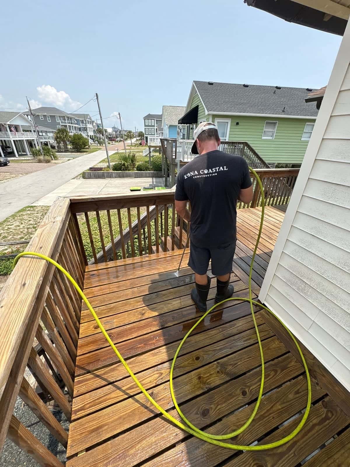Kona team member cleaning a weathered wood deck in the Wilmington, NC area