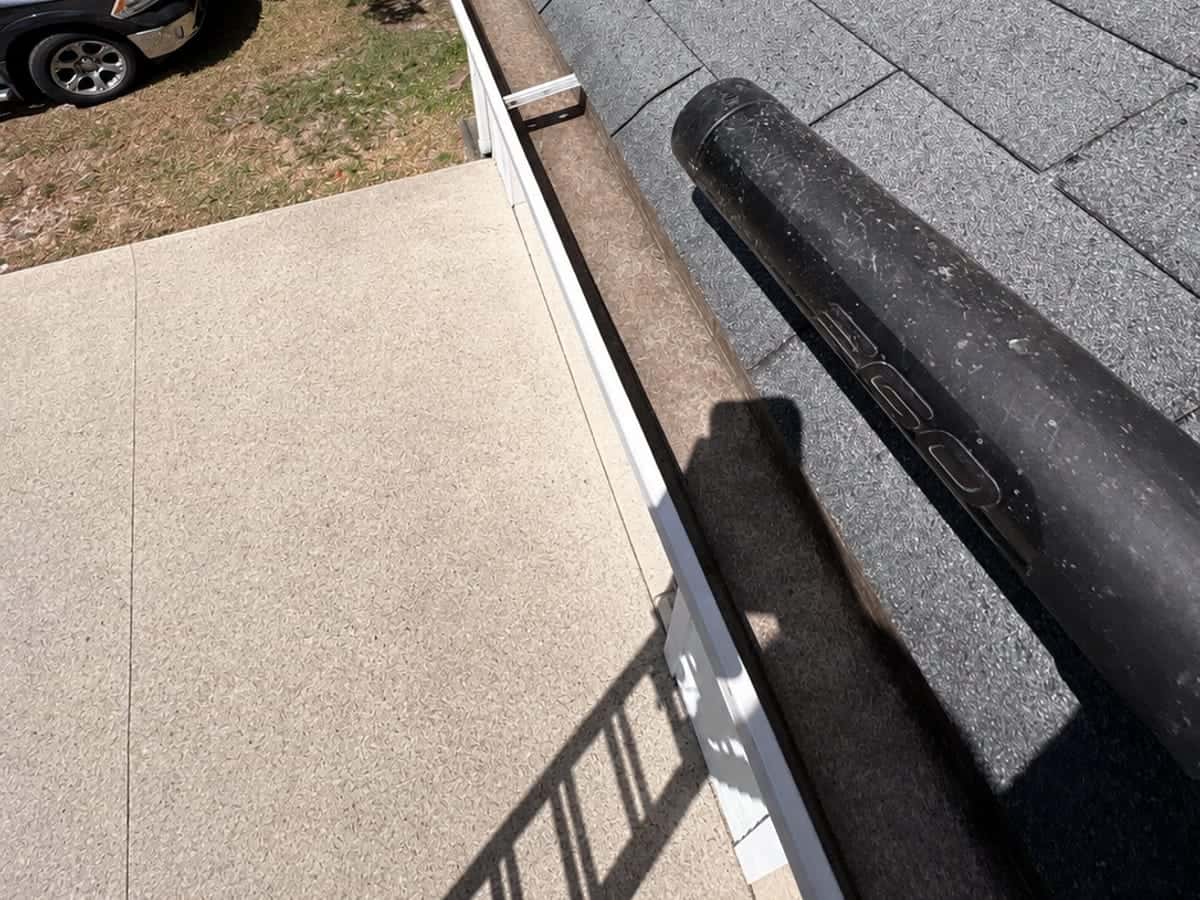 A clean gutter being cleared with a leaf blower on a home in the Wilmington, NC area