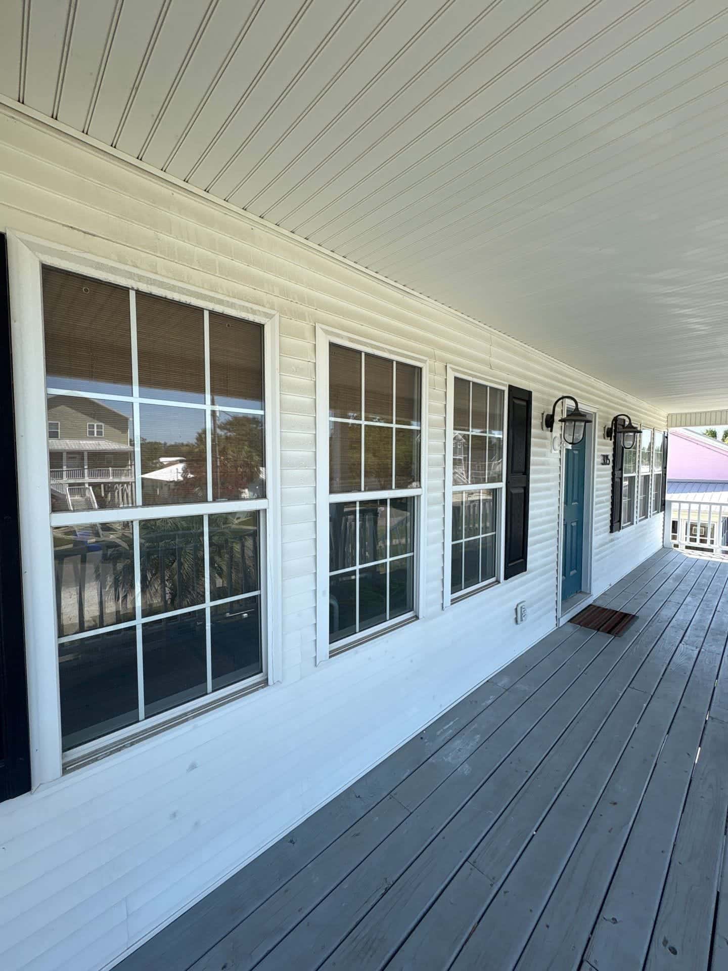 Before: Covered porch soft washing before and after in the Wilmington, NC area: siding and windows restored to bright white